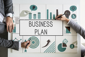 BUSINES PLANについて2人のスーツの男性がペンで書いている画像