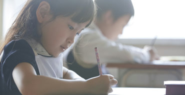 2人の子供が机で勉強している画像