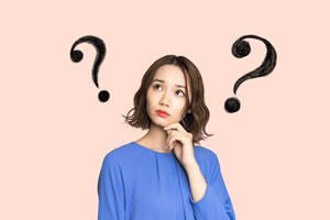 頬に手を添えて考えている女性の画像